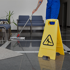 Someone cleans a floor as part of the rental mop program provided by Walk On Dust Control, a commercial floor mat rental service company in St. Catharines